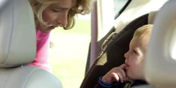 Woman putting boy in car seat - Little Rock Child Injury Attorney